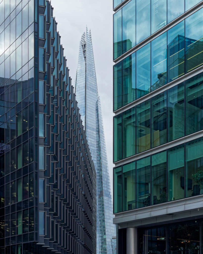 A striking view of modern glass buildings with The Shard in London's skyline, displaying urban architecture.
